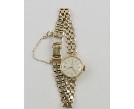 A 9ct Tudor ladies wristwatch with baton numerals on a 9ct gatelink strap.