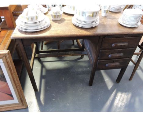 An oak three drawer single pedestal kneehole desk.