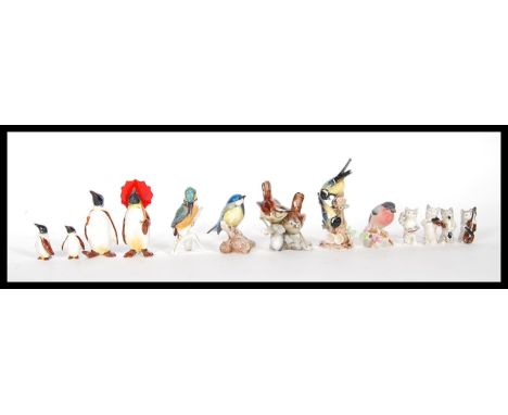 A selection of china figurines to include a group of four Beswick penguins including two large with one holding a parasol and