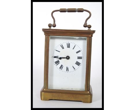 An early 20th Century French gilt brass cased carriage clock. The white enamel face with Roman numeral chapter ring having fa