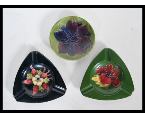 A group of three pieces of tube lined Moorcroft pottery, the first being a pin dish and the other two being ashtrays, each de