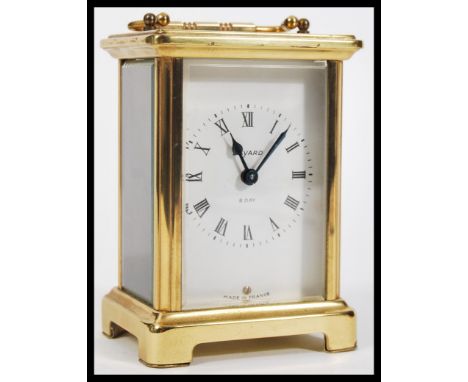 A Bayard French carriage clock with white enamel dial with Roman numerals along with swing handle and raised on bracket feet