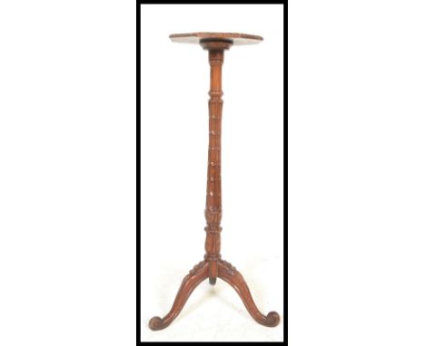 A 20th Century oak Torchere plant stand, raised on floral carve tripod supports, having&nbsp;foliate decorated column with oc