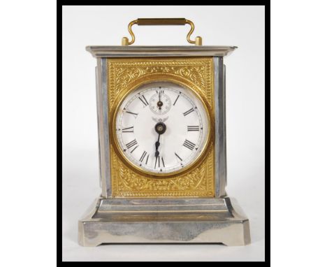 A 20th Century German made carriage clock. The clock of classical form, chrome case with gilt rococo in relief front panel, r