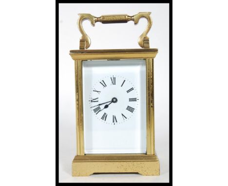 A 20th Century brass cased four pane carriage clock having a white enamelled face with roman numerals to the chapter ring, be