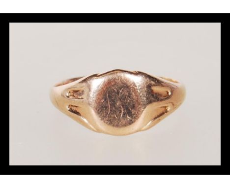 A hallmarked 9ct gold signet ring having a round cartouche to the head faintly engraved with the letter M. Hallmarked Birming