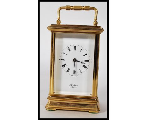 A 20th Century St James of London gilt brass carriage clock, the enamel dial with Roman numerals, on plinth base, with carry 