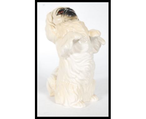 A 20th Century Beswick ceramic figure of a begging Pekingese dog with hand painted details. Stamped Beswick to the base. Meas