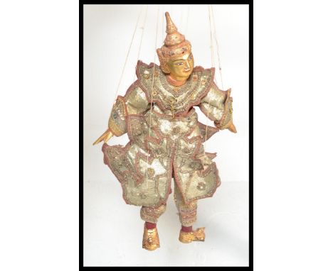 A Vintage Antique Thai string wooden puppet, wearing sequin garments having gilt finish to hands, feet and head with hand pai