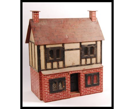 A vintage 20th Century Triang style scratch built Tudor style dolls house having painted brick exterior with painted tile roo