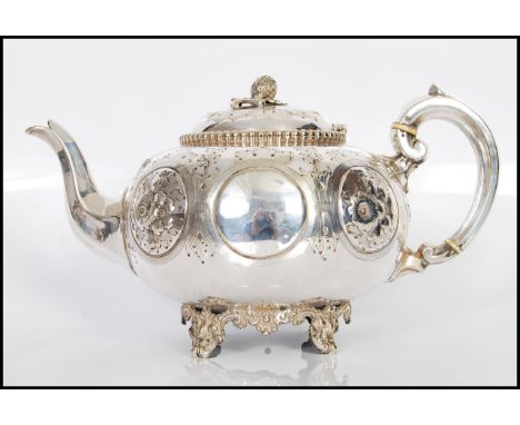 A 19th Century Victorian silver plate teapot having repousse and engraved floral decoration raised on rococo style feet and d