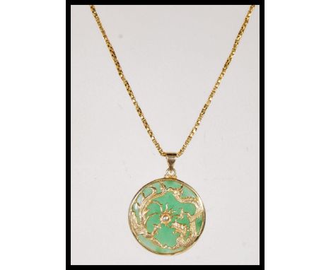 A gold on silver stamped 925 Chinese Jade pendant of circular form, having Dragon and Phoenix decoration, on a box link chain