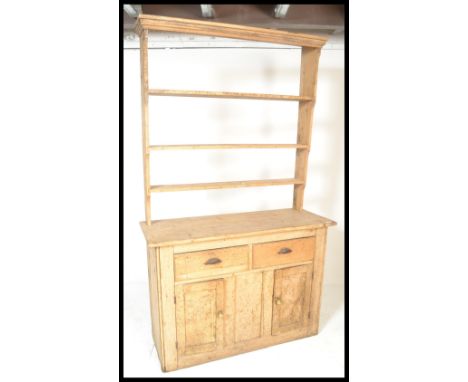 A Victorian 19th century pine country Welsh Dresser. The base with short drawers over double door cupboard having shelf withi