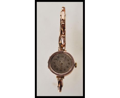 An early 20th Century Art Deco having a 9ct gold case and bracelet expandable, with a round face having Arabic numerals to th