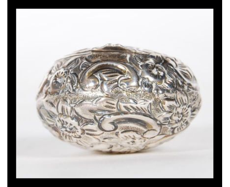 An early 20th Century silver hallmarked snuff / pill box of bulbous form having repousse floral decoration with an unmarked c