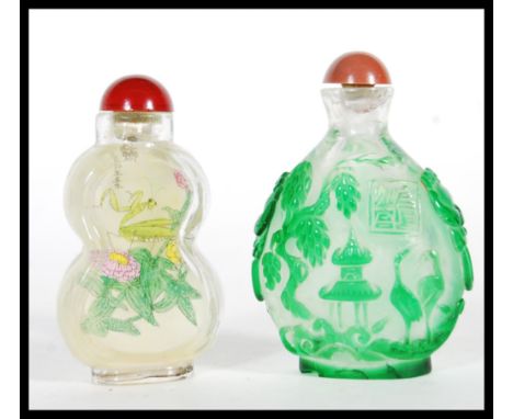 Two 20th century Chinese glass snuff bottles both with stoppers, the first having had painted grasshopper, flower and Chinese