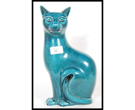 A Poole studio pottery ceramic figurine modelled as a seated cat with a turquoise glaze. Stamped to the base. Measures 30 cm 