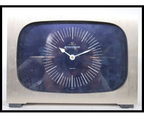 A 1970's Jaeger-LeCoultre table clock set within a brushed aluminium case with back cover having baton numerals with night bl