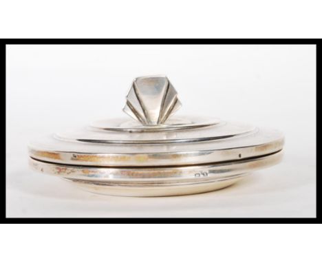 A silver hallmarked Art Deco 1930's dressing table powder pot having an engine turned stepped design lid with a fan finial an