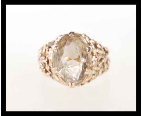 A 9ct Gold hallmarked dress ring, of openwork filigree design set with a large faceted cut paste stone. Gross weight 5.97g.