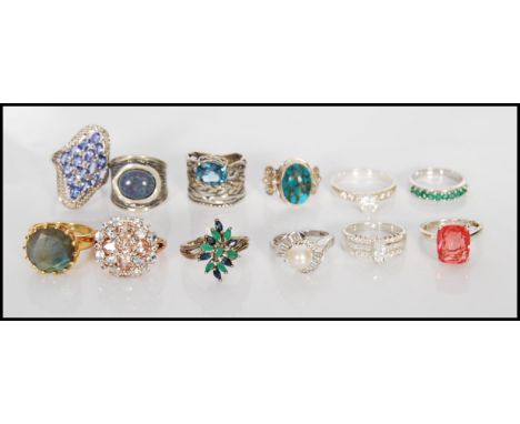 A group of 12 stamped 925 silver ladies dress rings to include a split band ring having a flower head set with green and blue