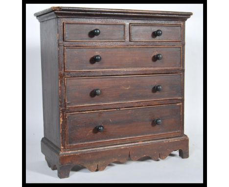 A Victorian 19th century apprentice piece miniature chest of drawers&nbsp; of stained pine construction. Raised on bracket pl