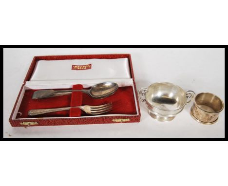 A cased silver hallmarked spoon and fork christening set retailed by Mallorys of Bath together with a silver hallmarked napki