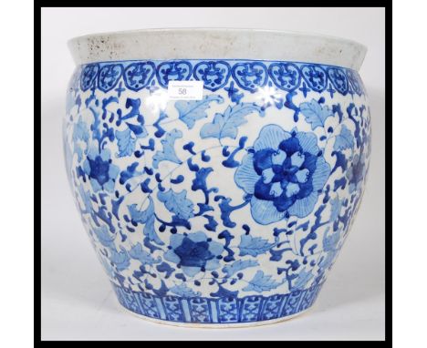 A large 20th Century ceramic planter pot of bulbous form having having painted blue floral patterning on a white ground and k