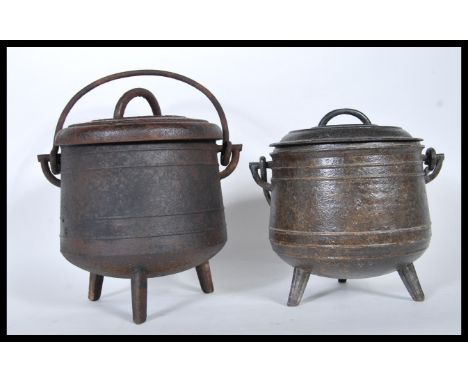 A pair of vintage 20th Century cast iron pot bellied cauldrons with lids, the pots used for the cooking of chestnuts in the e