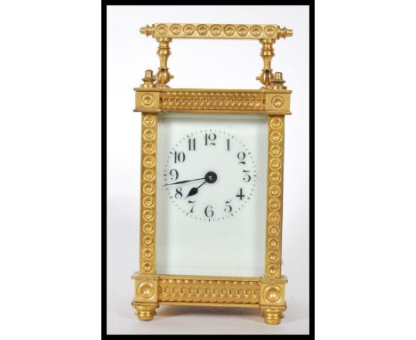 A 20th Century brass carriage clock having four glass panelled sides exposing the mechanism to the interior, and white enamel