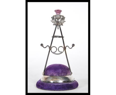 A silver hallmarked Britton, Gould &amp; Co&nbsp;hat pin stand having a purple velvet cushion base with a Scottish thistle fi