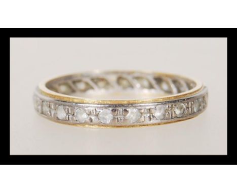 A stamped 18ct gold two tone eternity band ring being set with white stones. Weight 2.0g. Size K.