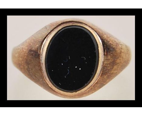 A 9ct gold hallmarked signet ring, set with an unmarked black cabochon stone. Size M, Gross weight 2.2g