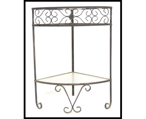 A vintage 20th century glass and forged metal corner table / side table having scroll decoration and glass shelf underneath. 