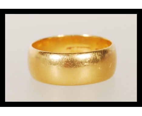 A hallmarked 22ct gold wedding band ring of typical form. Hallmarked Birmingham 1965. Weight 7.4g. Size O.5.