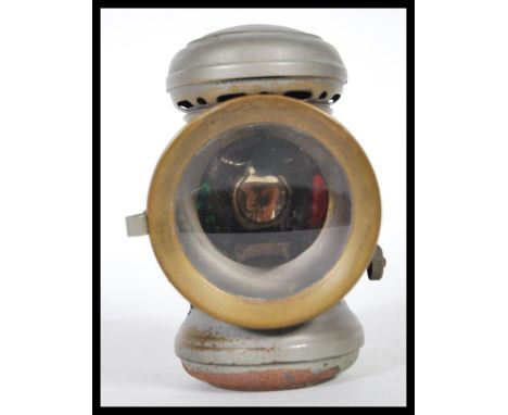 A early 20th Century bicycle lamp by Joseph Lucas captain, having magnifying lens and green/red side lenses, burner and sprun