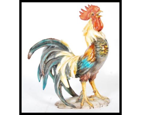 A 20th Century Italian Majolica ceramic cockerel rooster in a standing and crowing position, being hand painted with original