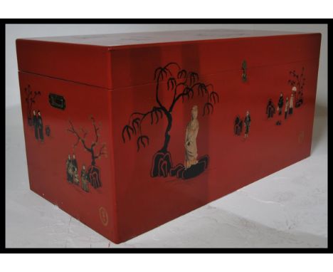 A large decorative 20th century Red lacquer Chinese chest / trunk. The red painted body with chinoiserie decorated scenes wit