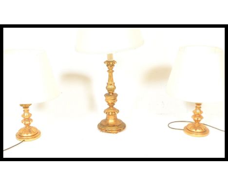 A gilt wood gesso table lamps with a matching pair of smaller garniture lamps, the matching baluster lamps modelled as acanth