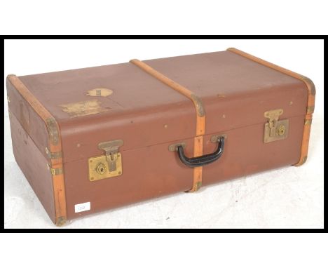 A vintage 20th Century canvas and cane bound steamer trunk, hinged top with latches to the front and leather carry handles to