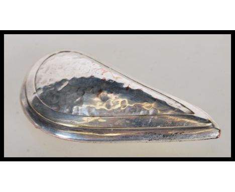 A 20th Century silver on copper novelty snuff/ pill box in the form of a mussel with hammered shaping and a hinged opening to