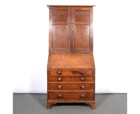George III oak bureau bookcase, adapted moulded cornice, the upper section with panelled doors enclosing adjustable shelves a