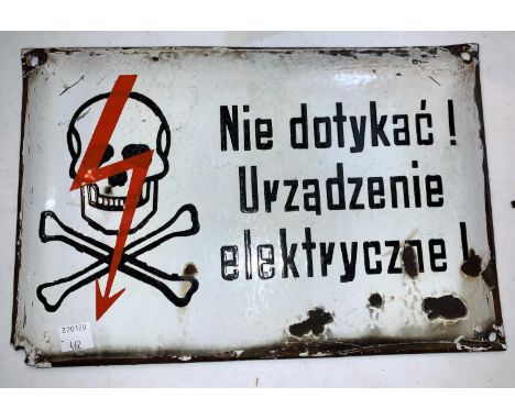 A vintage enamel electrocution warning sign in polish