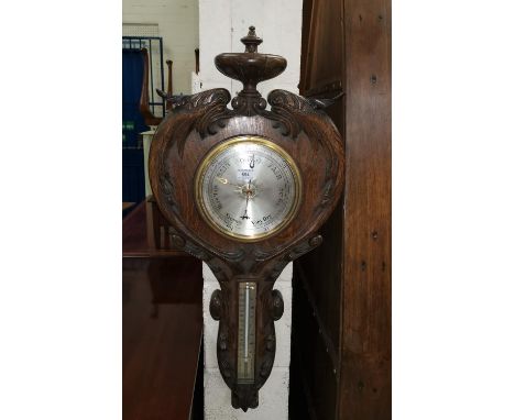 A late Victorian barometer with thermometer in carved oak case 