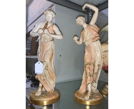 A late 19th century pair of Royal Worcester figures of classical women, one playing the pipes and one dancing, height 32 cm (