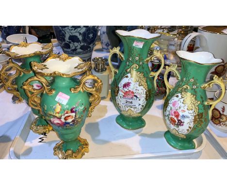A 19th century pair of 2 handled baluster vases in the rococo style, with polychrome floral decoration against a green ground