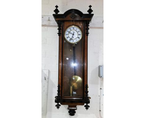 A 19th century walnut Vienna wall clock, with ebonised mouldings and finials, white enamel dial and single weight driven move