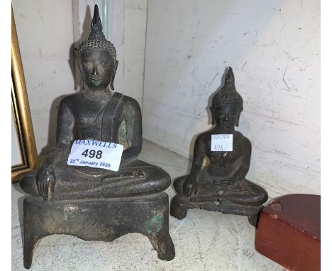 A far eastern bronze figure of Buddha, 20 cm, later wooden stand; a similar smaller figure, 14 cm 