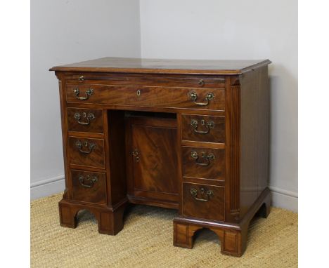 Early George III figured mahogany kneehole desk, with canted and reeded front corners, slide and cupboard to kneehole, on mou