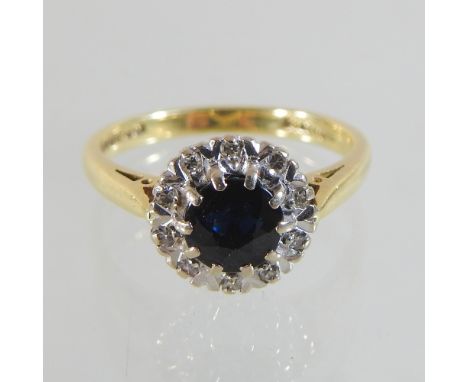 An 18 carat gold sapphire and diamond cluster ring, boxed